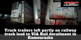 Truck trailers left partly on railway track lead to VIA Rail derailment in Kamouraska Nighttime photo montage of two truck trailers, one branded HGC Harman Group and the other Ameri-Can Systems, parked in a snowy yard near a railway line. The headline on the graphic reads: “Truck trailers left partly on railway track lead to VIA Rail derailment in Kamouraska,” with the TruckStopCanada.com logo in the upper right corner.